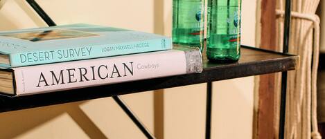 A bookshelf with books and two bottles of water.