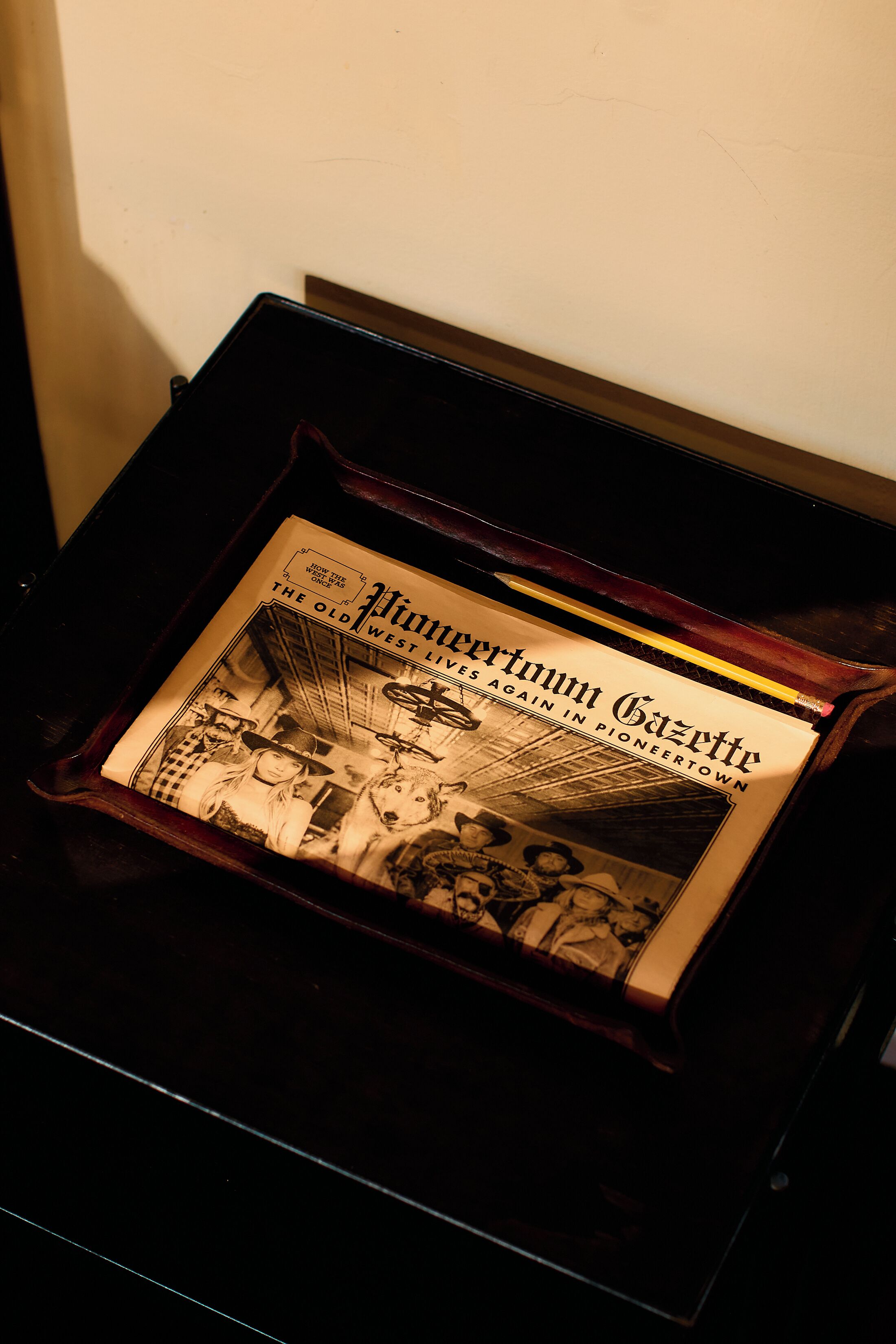 A vintage newspaper titled 'The Old Pioneertown Gazette' inside a wooden box.