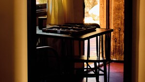 A room with a wooden table, a chair, and a window with curtains.