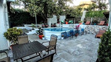 Una piscina al aire libre, sillones reclinables de piscina