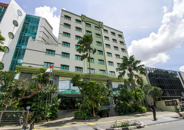 A multi-story hotel with a modern design, featuring a prominent entrance with a covered area and lush landscaping. - Paragon Gallery Hotel (Jakarta)