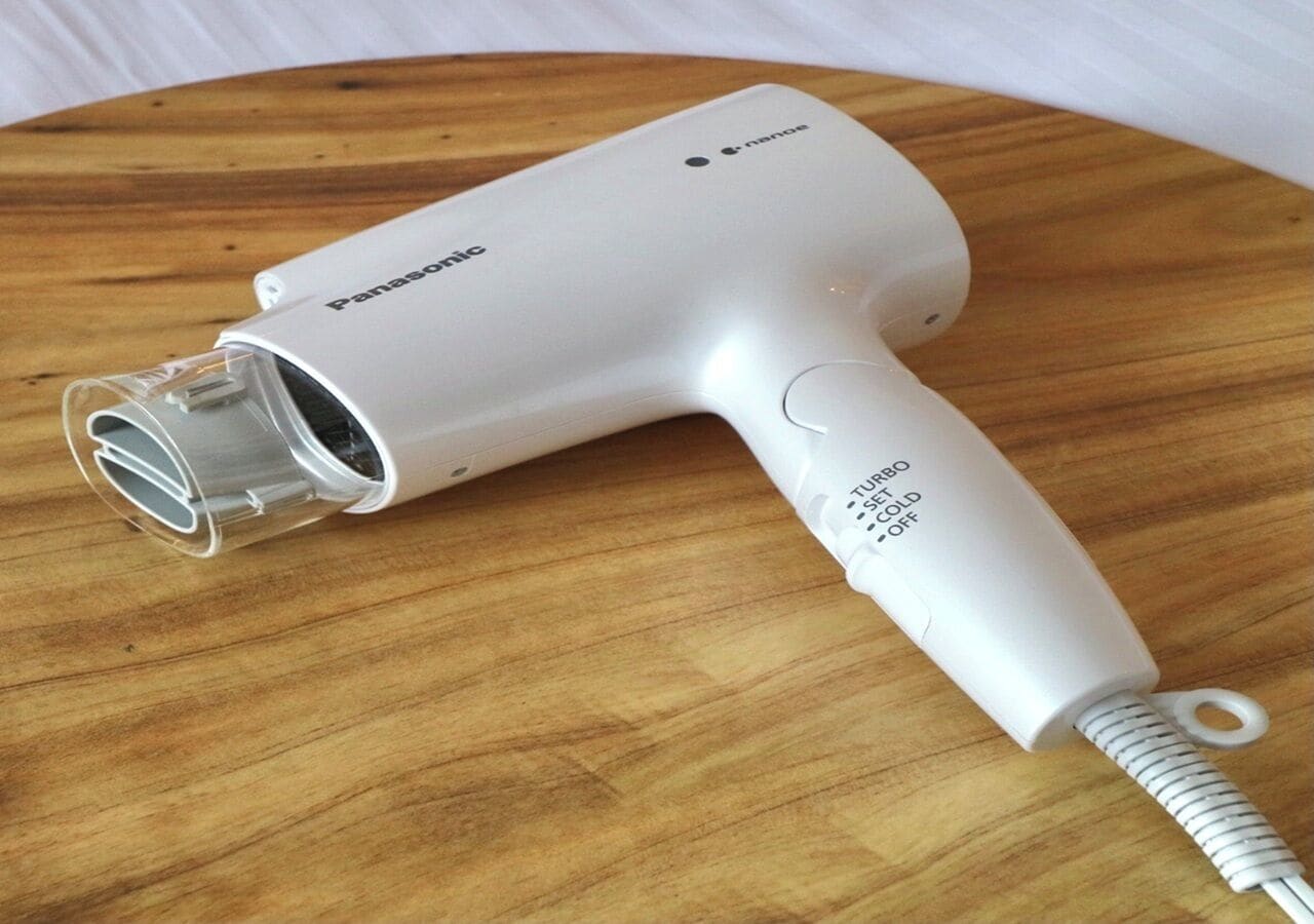 A Panasonic hair dryer with a transparent nozzle and a control panel indicating turbo, cold, and off settings.