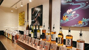 Una zona de bar con diferentes botellas de alcohol y tarjetas informativas.
