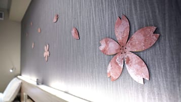 Un mur orné d’une grande décoration en métal rouillé en forme de fleur, ainsi que de plusieurs autres motifs en métal, plus petits.