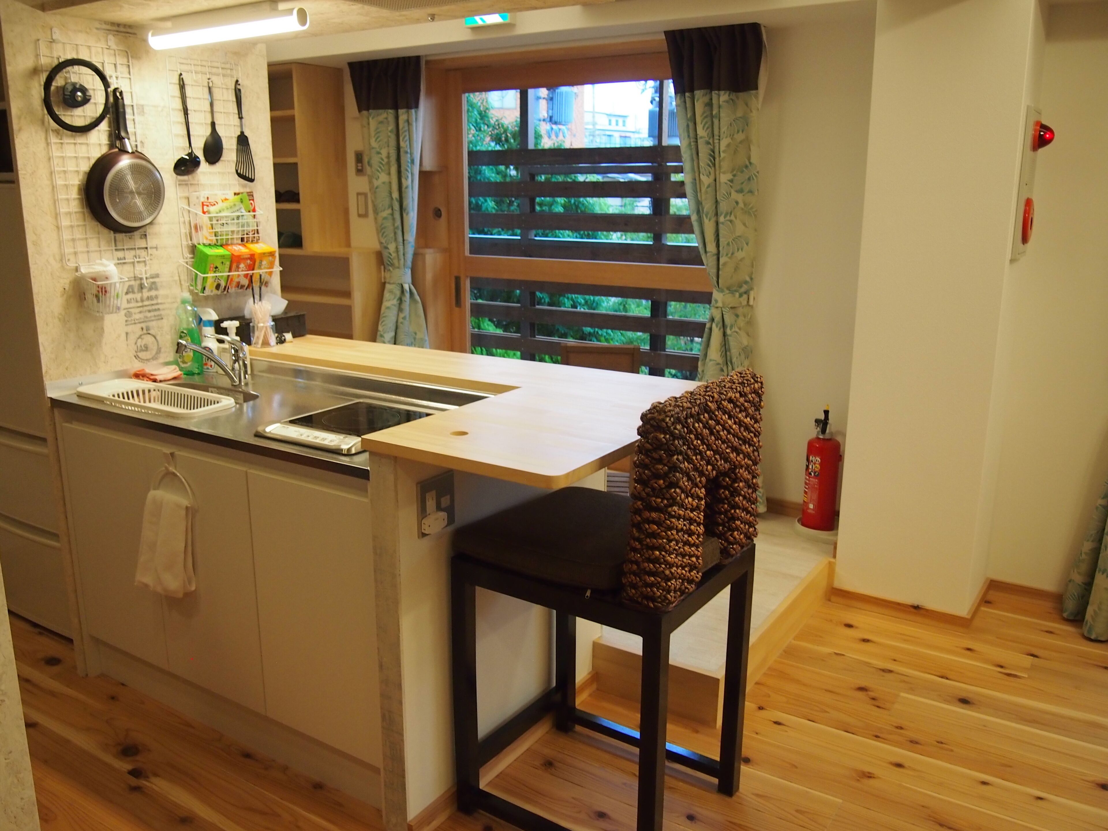 A compact kitchen with a wooden countertop, a sink, and a window with a view of greenery.