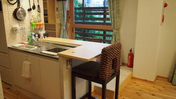 A compact kitchen with a wooden countertop, a sink, and a window with a view of greenery.