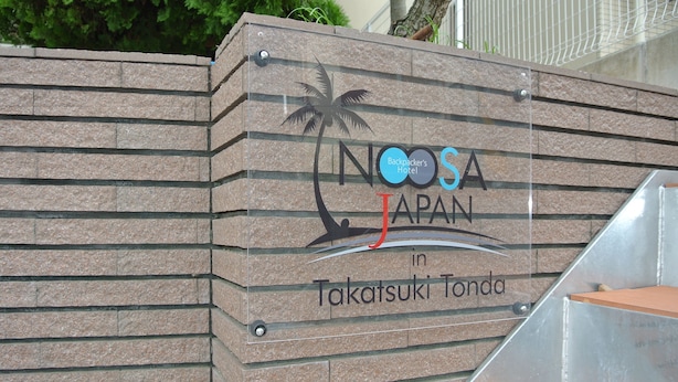A sign for Noosa Japan in Takatsuuki Tonda, featuring a palm tree and waves graphic.