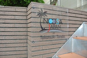 Letrero de Noosa Japan en Takatsuuki Tonda, con un gráfico de palmera y olas.