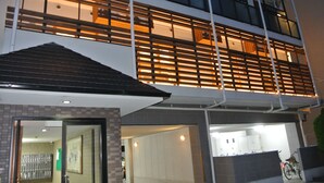 A modern building with a two-story structure, large windows, and a covered entrance area.