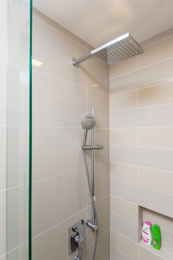 A shower with a glass door, a handheld showerhead, and a wall-mounted control panel. - RH Suites at One Bukit Ceylon (Kuala Lumpur)