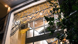 A building facade with ornate metalwork, large windows, and a staircase. - Point Boutique Hotel (Phnom Penh)