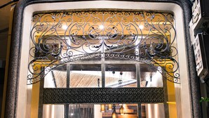 A boutique hotel entrance with ornate ironwork, a glass door, and a wooden interior visible through the door. - Point Boutique Hotel (Phnom Penh)