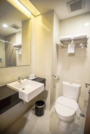 A modern bathroom with a white sink, toilet, and shower area. - Happy Inn Melawai (Jakarta)