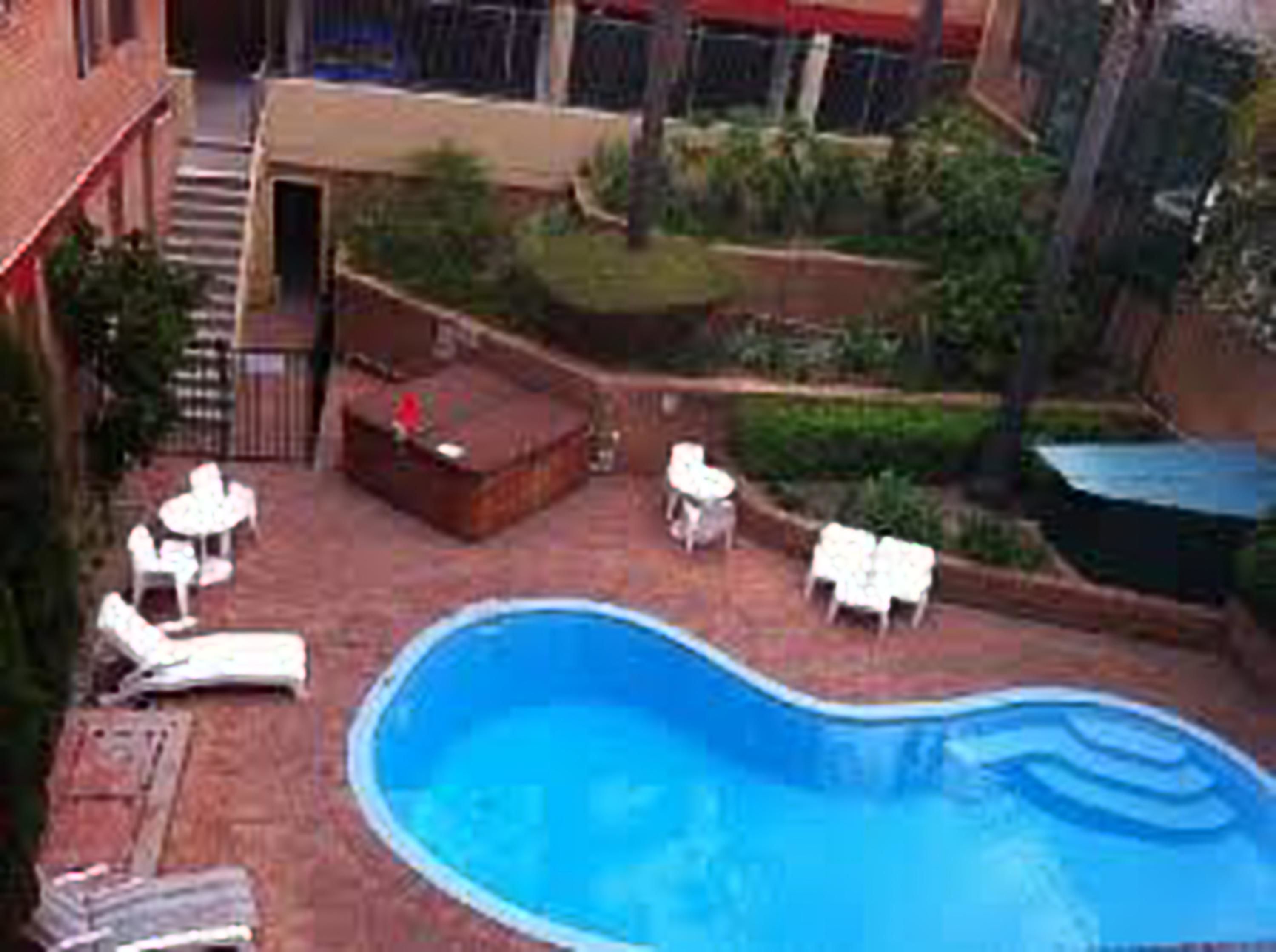 A swimming pool with lounge chairs and a small deck area.