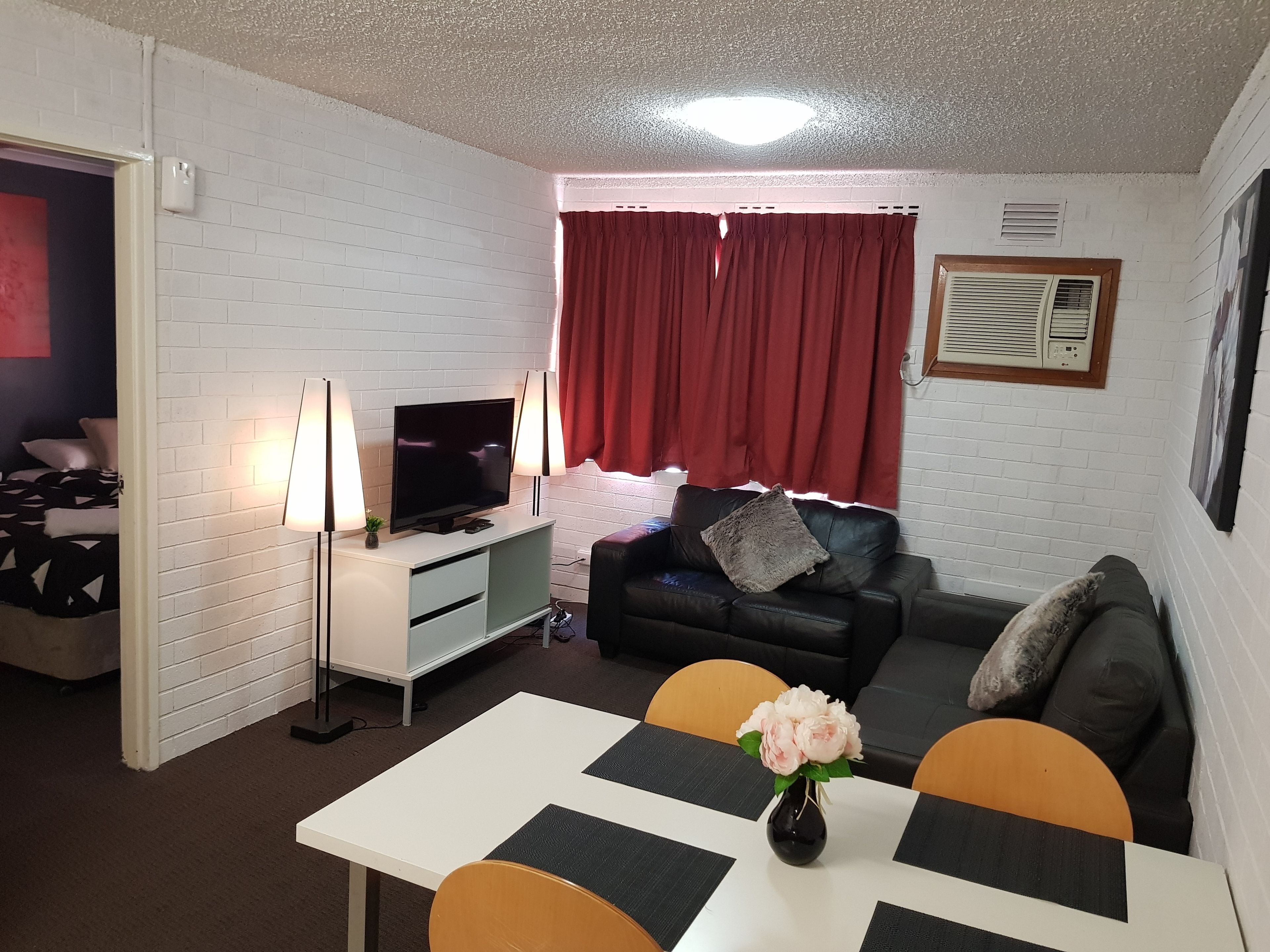 A living room with a television, sofa, and dining table.