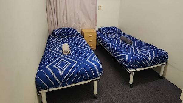 A room with two beds, a ceiling fan, and a light fixture. - Perth City Apartment Hotel (West Perth)