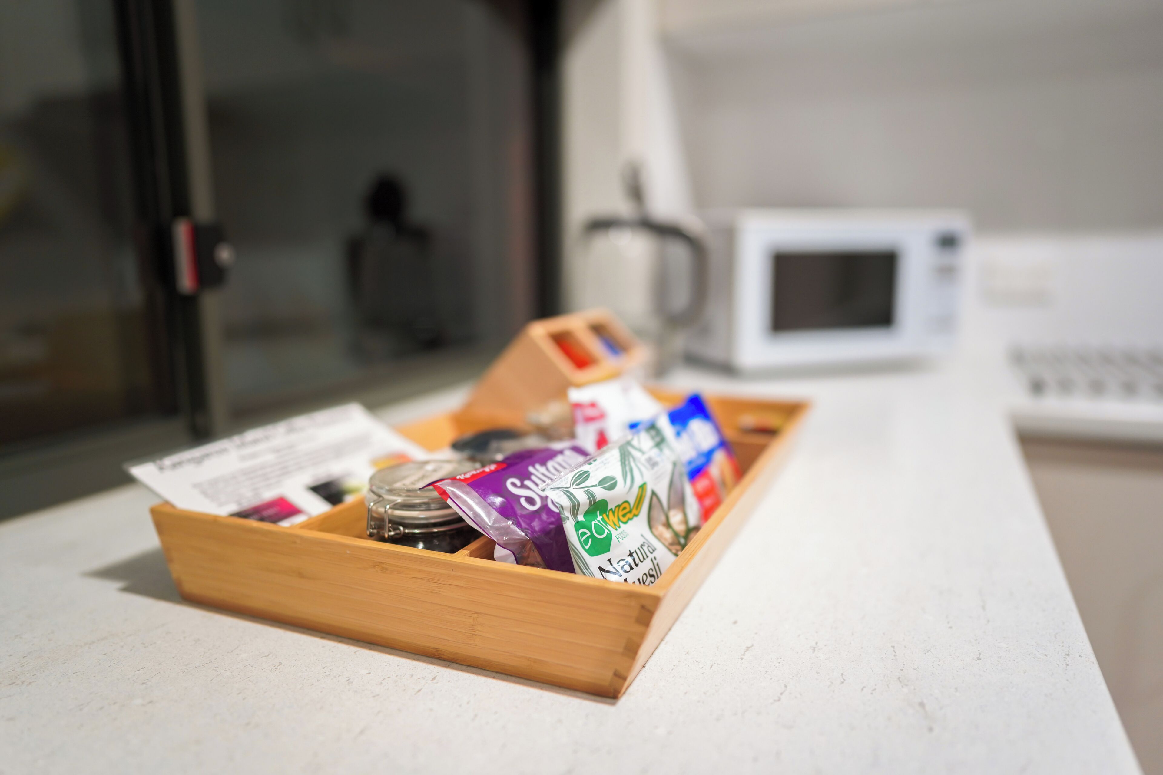 A wooden tray with food items and a receipt on a kitchen counter.