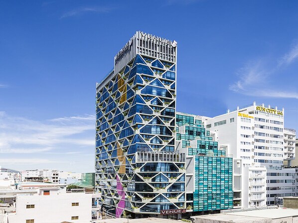 A modern building with a unique geometric facade, featuring the 'VENUE' logo.