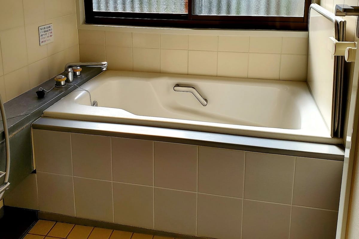 A bathroom with a bathtub, a toilet, and a sink.