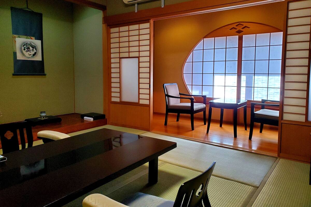 A traditional Japanese-style room with tatami flooring, a low table, and sliding doors.