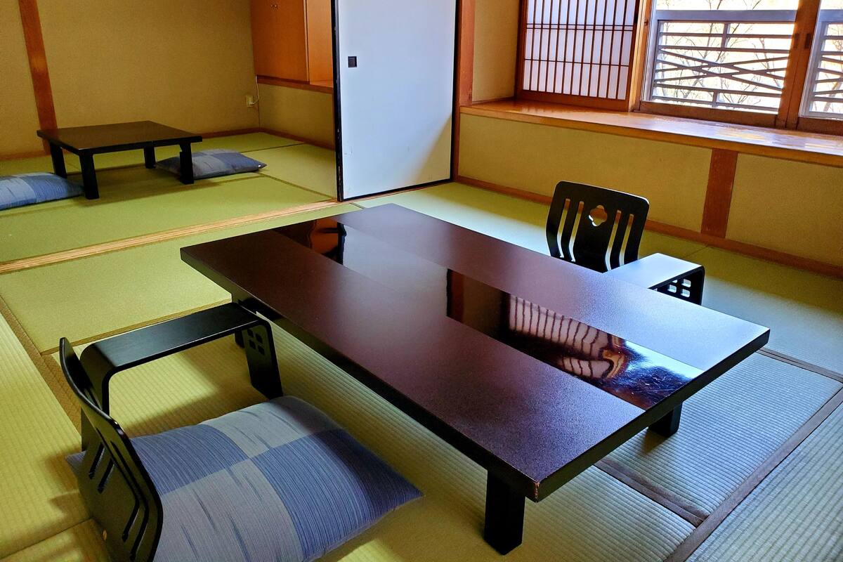 A traditional Japanese tatami room with a low table and seating.
