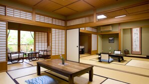A traditional Japanese room with tatami flooring, low tables, and sliding doors. - Yufuin Santokan (Yufu)