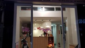 L’entrée d’un hôtel, avec une enseigne au néon indiquant « HONG VINH ».