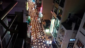 Une vue de rue de nuit, avec des lampadaires illuminés et un bâtiment éclairé par des néons.