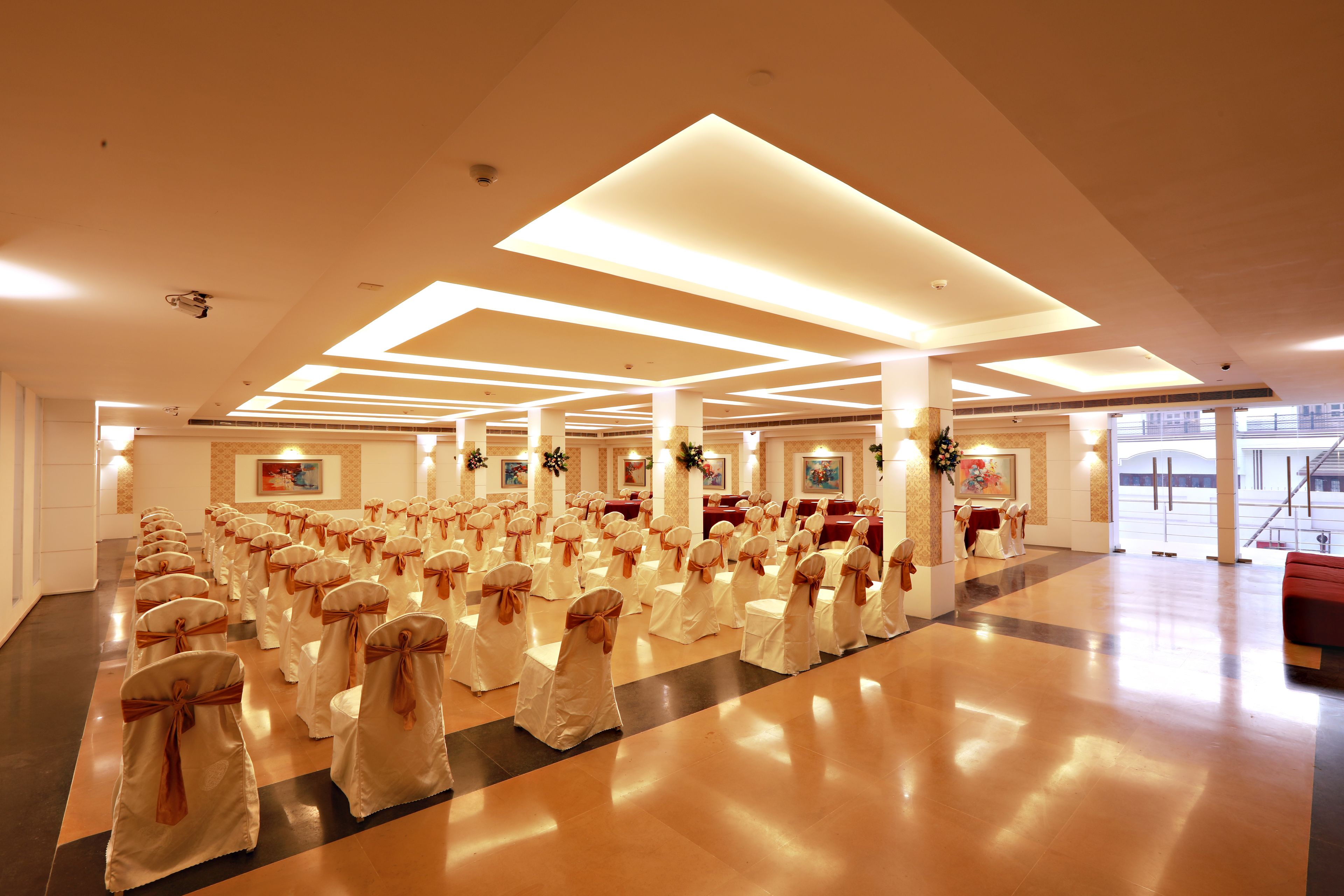 A spacious hall with rows of chairs and tables, likely for a formal event.