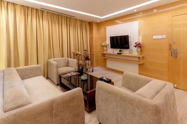 A modern living room with a sofa set, a coffee table, and a flat-screen TV mounted on the wall. - Hotel Patliputra Continental (Patna)