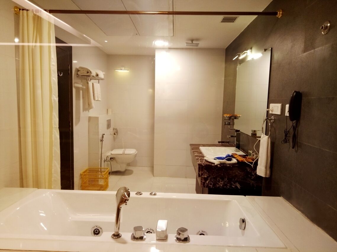 A modern bathroom with a large bathtub, a separate shower area, and a vanity with a mirror.