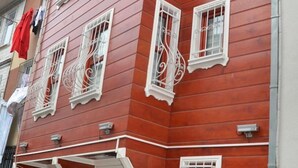 A red building with white window frames and decorative ironwork. - Sophia Studio Apartments (Istanbul)