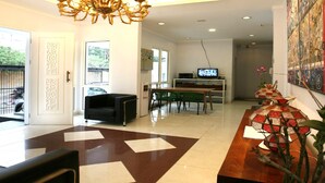 Una sala de estar moderna con una araña, una mesa de comedor y un televisor.