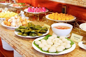 A buffet with various dishes including stuffed pancakes, fish sauce, and other Asian cuisine.