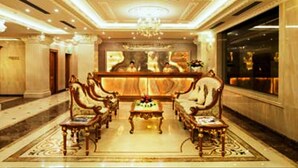 Un'elegante hall con arredi ricercati, una reception centrale e un lampadario.