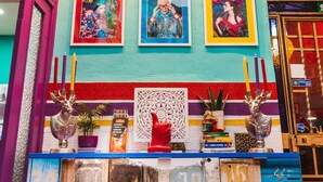 A room with colorful walls, framed artwork, and a decorative number board. - Rio Hostel (Seville)