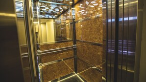 An elevator interior with reflective metallic walls and a marble floor. - Express Inci Airport Hotel (Istanbul)