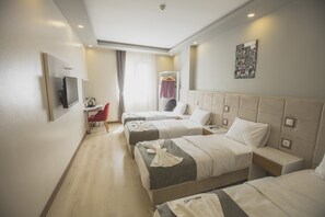 A hotel room with three beds, a TV, a desk, and a chair. - Express Inci Airport Hotel (Istanbul)