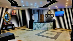 A hotel lobby with a reception desk, a clock, and a television. - Express Inci Airport Hotel (Istanbul)