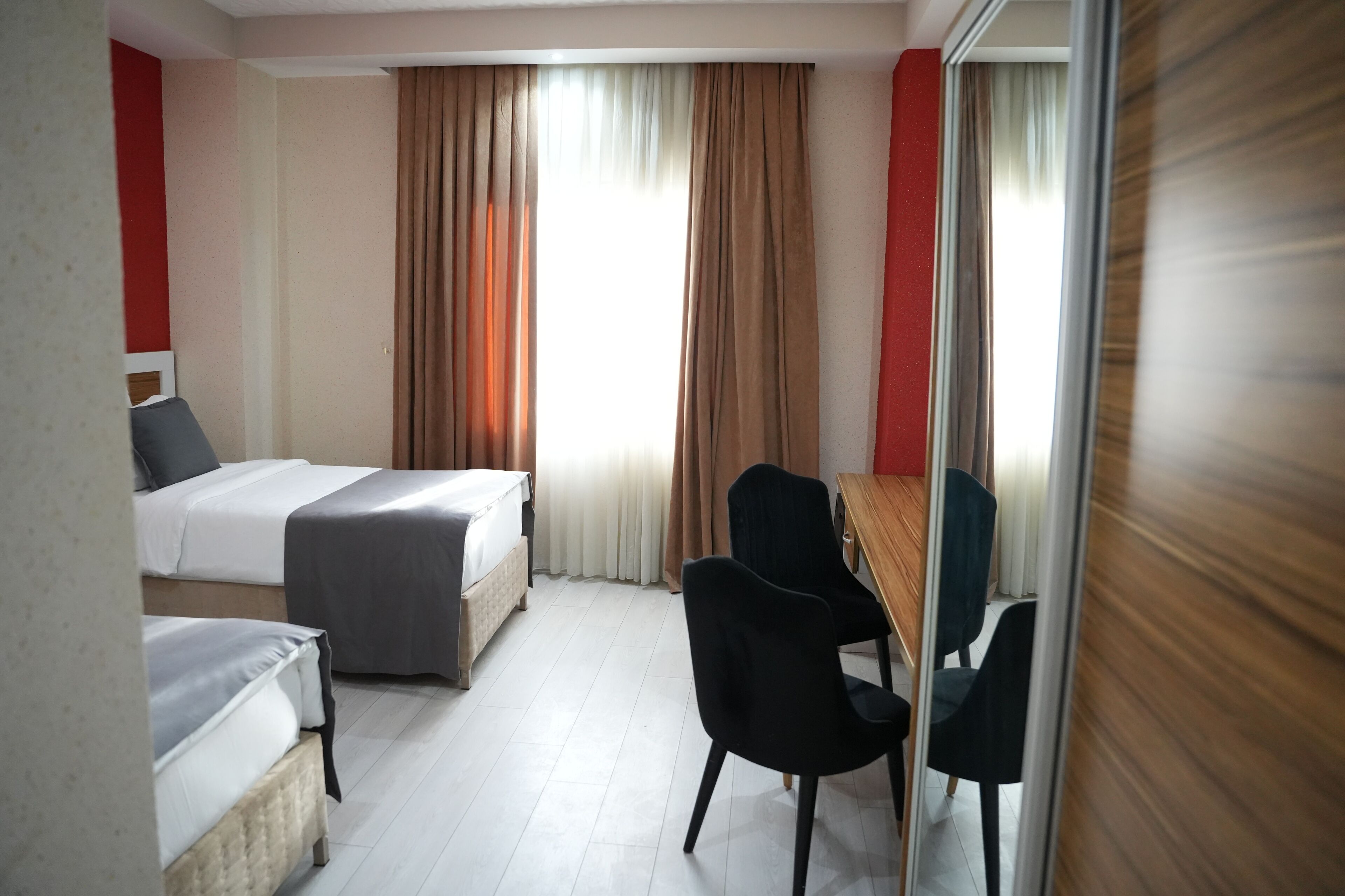 Ein Hotelzimmer mit zwei Betten, einem Schreibtisch und einem Stuhl.