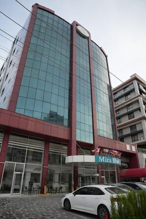 Un bâtiment moderne doté d’une façade en verre, d’une entrée bien visible et d’une enseigne indiquant « Mira Blue ».