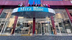 A modern building with a prominent blue glass facade and a sign reading 'Mira Blue.'