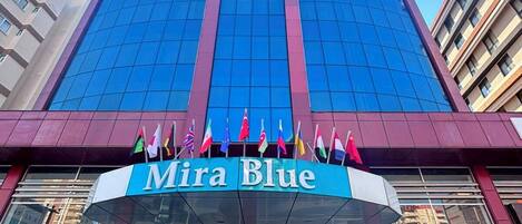 A modern building with a prominent blue glass facade and a sign reading 'Mira Blue.'