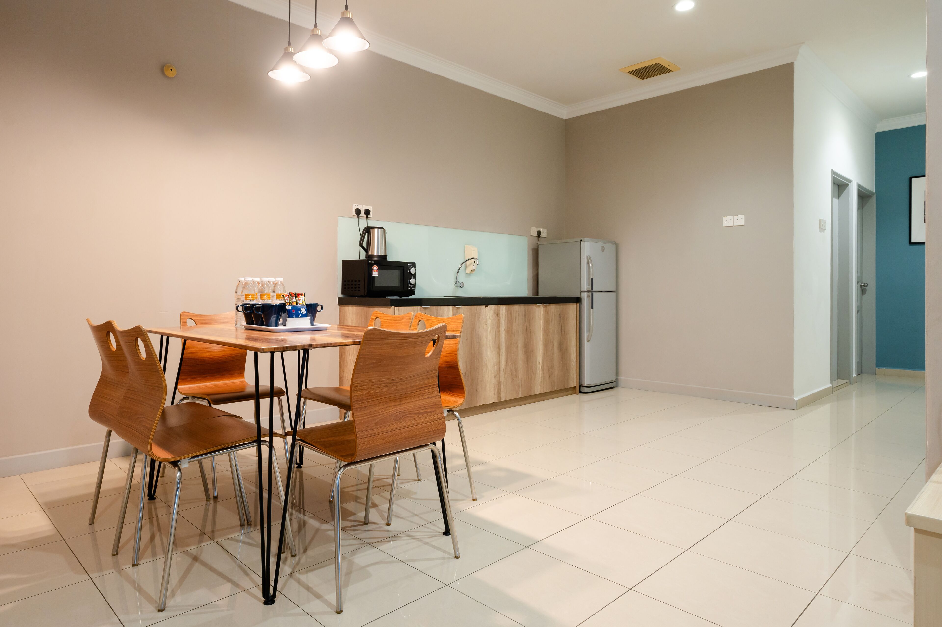 Een moderne keuken met een eetgedeelte, met een keukeneiland, stoelen en een koelkast.