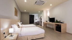 A hotel room with two beds, a desk, a TV, and a bookshelf. - Golden View Serviced Apartment (George Town)
