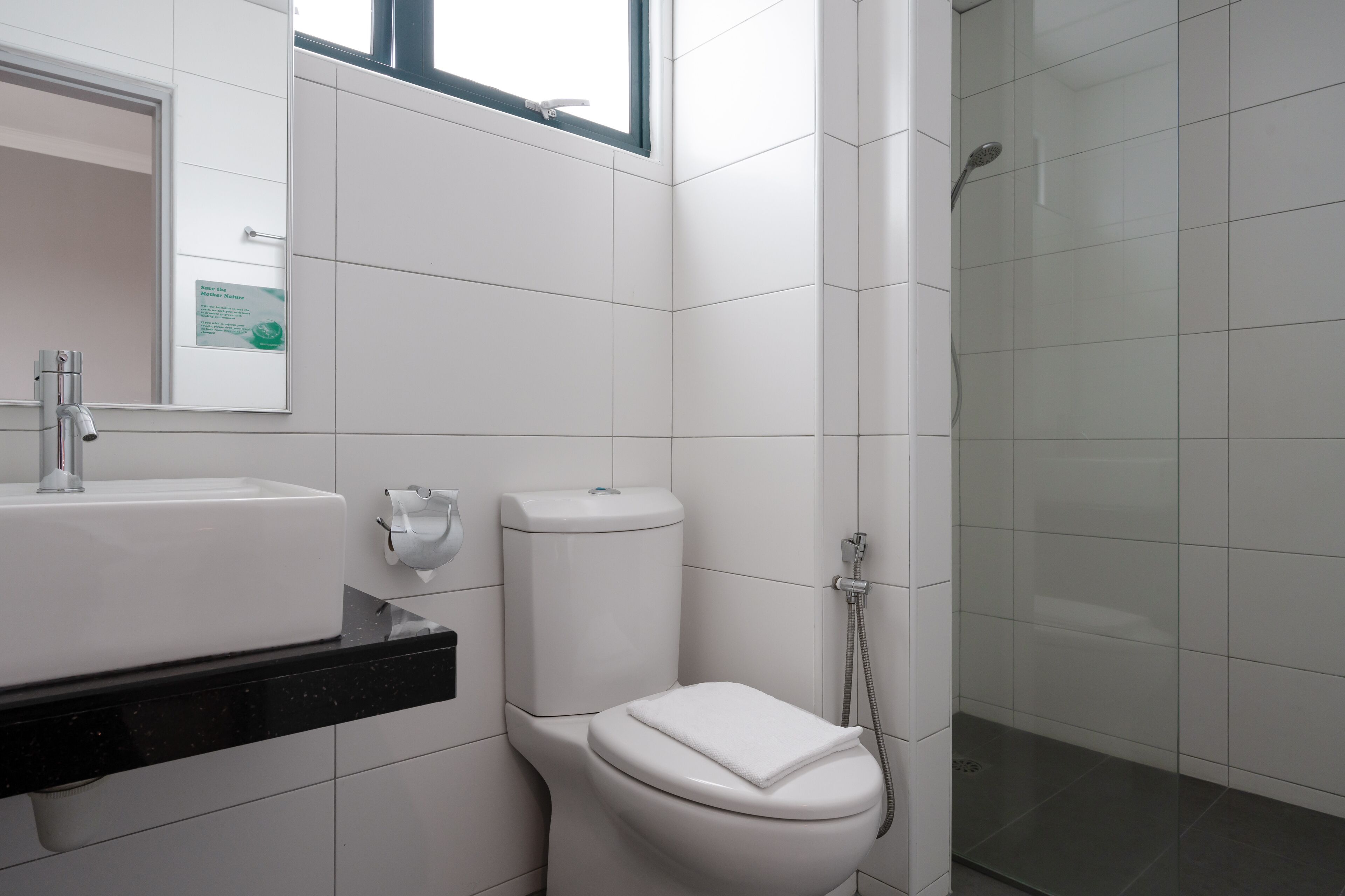 A modern bathroom with a white sink, toilet, and shower.