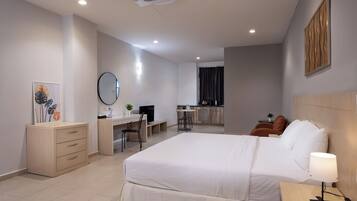 Une chambre d’hôtel équipée d’un lit, d’un bureau, d’une chaise et d’une petite kitchenette.