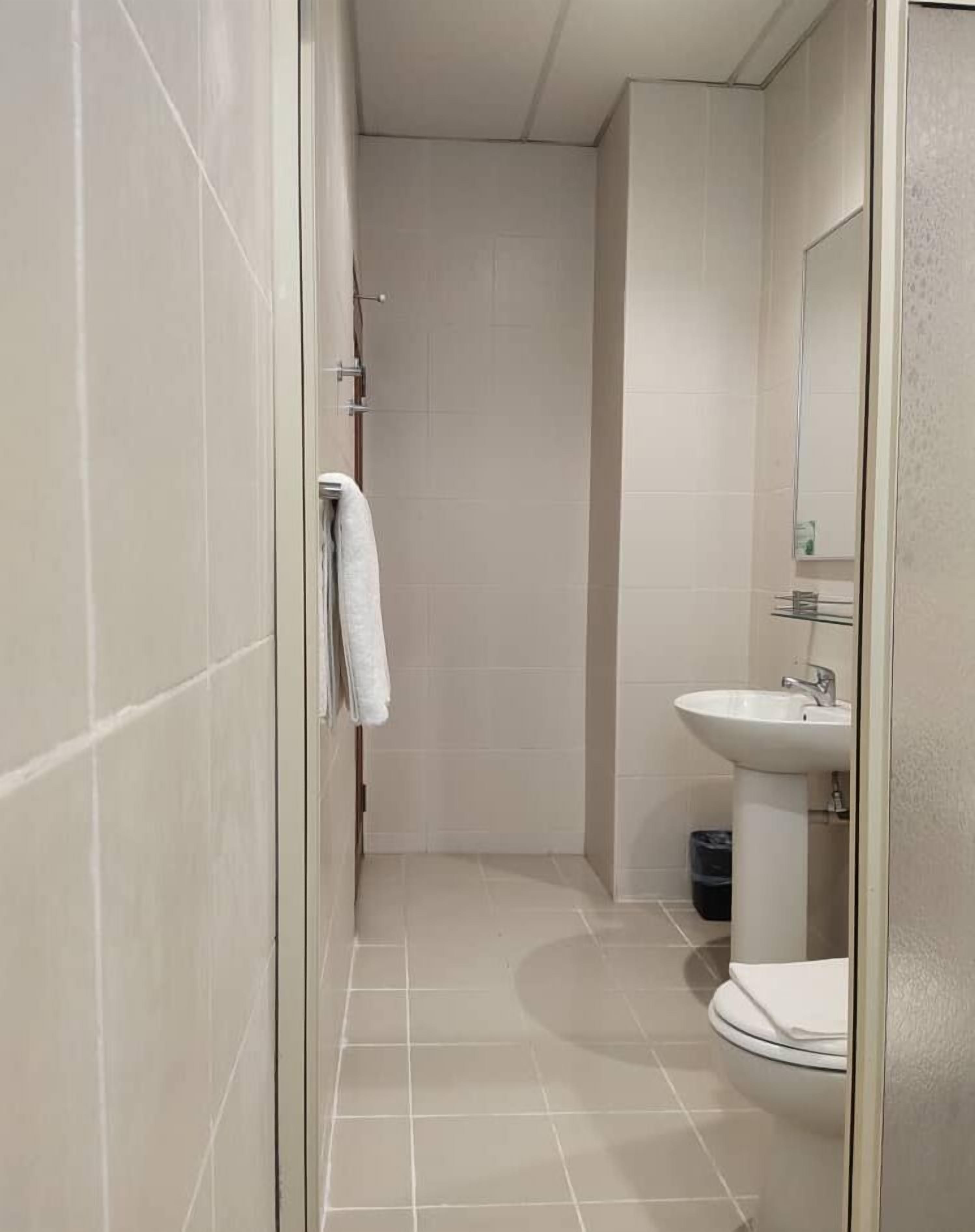 A bathroom with a shower, a sink, and a toilet.