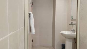 A bathroom with a shower, a sink, and a toilet.