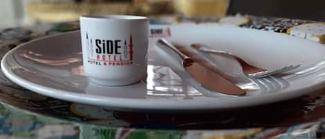 Una mesa con un plato, una taza y cubiertos.